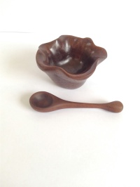 small palm sized hand carved walnut bowl with tiny spoon, used as a salt bowl